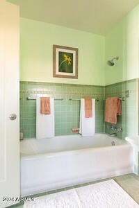 bathroom featuring tile walls and  shower combination