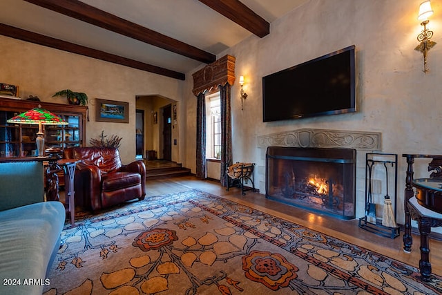 living room featuring beamed ceiling and hardwood / wood-style floors