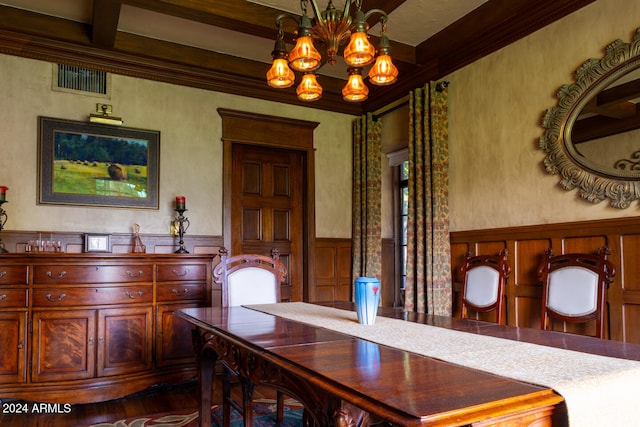 dining room with beamed ceiling, hardwood / wood-style floors, ornamental molding, and an inviting chandelier