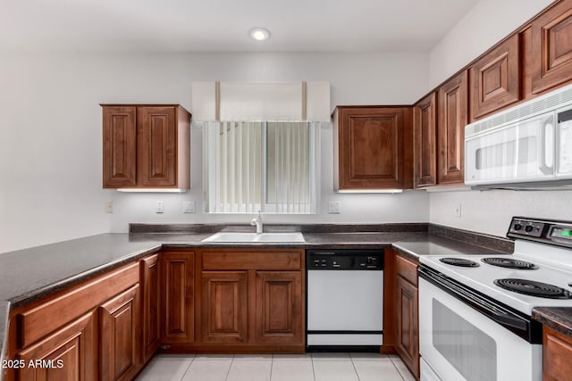 14609 W Black Gold Ln, Sun City West, AZ 85375 - kitchen featuring white appliances, a sink, dark countertops, brown cabinetry, and recessed lighting