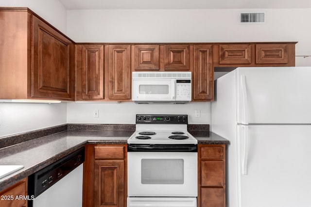 14609 W Black Gold Ln, Sun City West, AZ 85375 - kitchen featuring white appliances, dark countertops, and brown cabinets