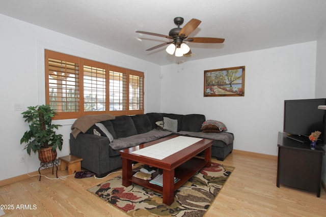 living area with ceiling fan, light wood finished floors, and baseboards