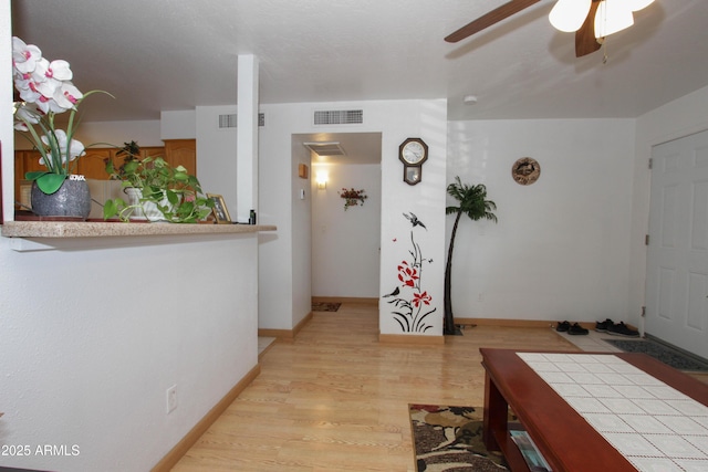 interior space with light wood finished floors, visible vents, and baseboards