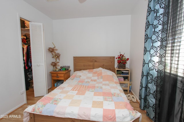 bedroom featuring a walk in closet, a closet, visible vents, light wood-type flooring, and baseboards