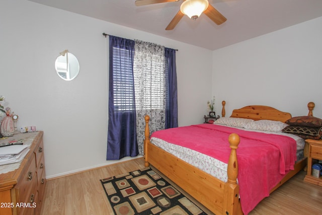 bedroom featuring light wood finished floors, ceiling fan, and baseboards