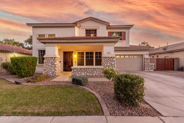 mediterranean / spanish-style house featuring a lawn, a garage, and covered porch