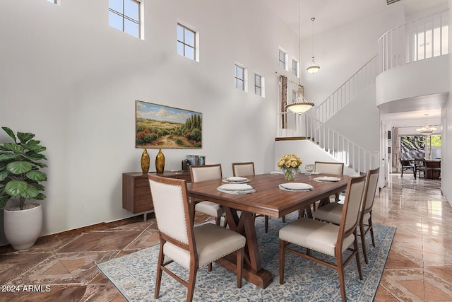 dining room featuring a notable chandelier and a towering ceiling