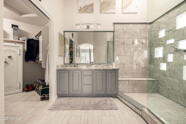 bathroom with vanity and tiled shower