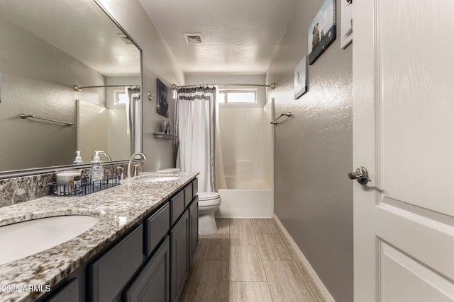 full bathroom with shower / tub combo with curtain, vanity, and toilet