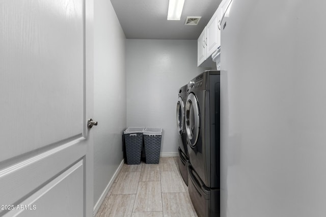 washroom featuring cabinets and separate washer and dryer