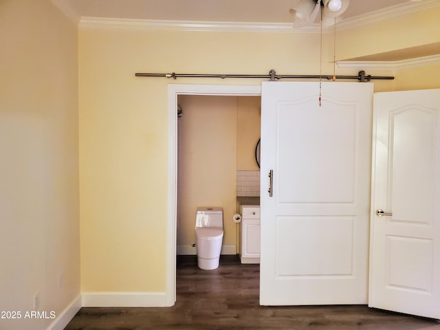 unfurnished bedroom with dark wood-type flooring, connected bathroom, and ornamental molding