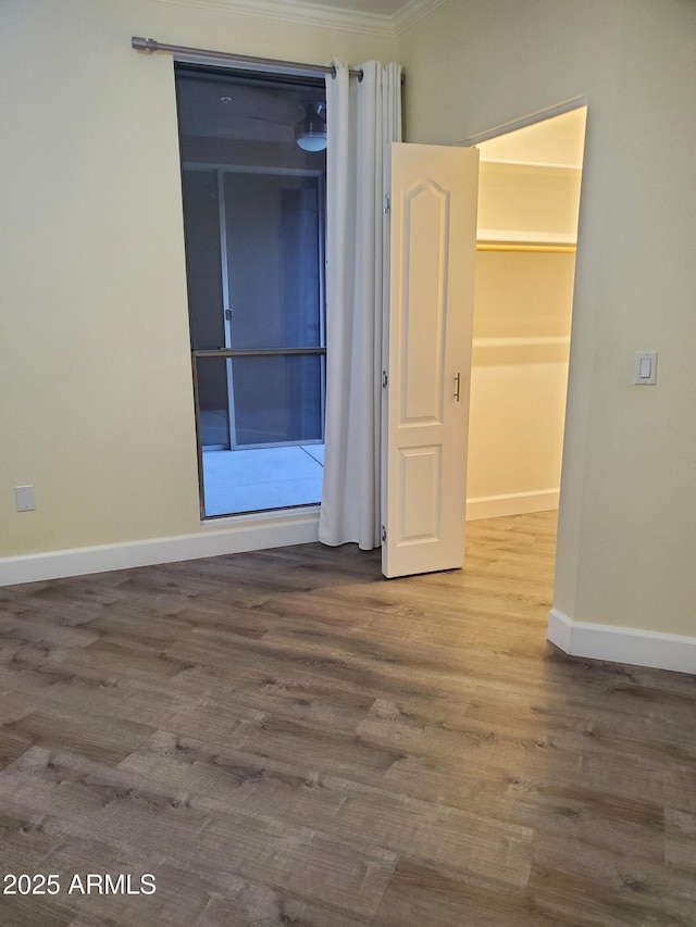 empty room featuring ornamental molding and wood-type flooring