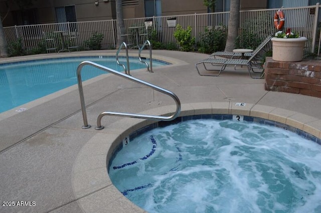 view of swimming pool featuring a hot tub