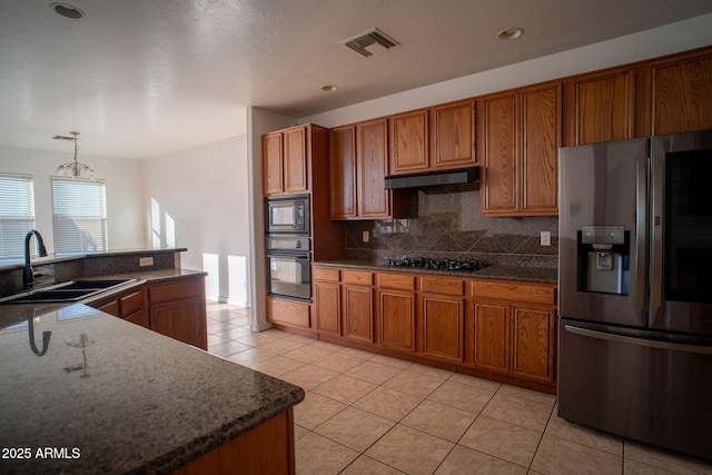 kitchen with black appliances, a sink, brown cabinets, and visible vents