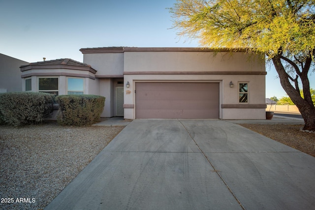 view of front facade featuring stucco siding, concrete driveway, and an attached garage
