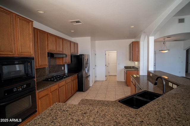 kitchen featuring black appliances, visible vents, under cabinet range hood, and a sink