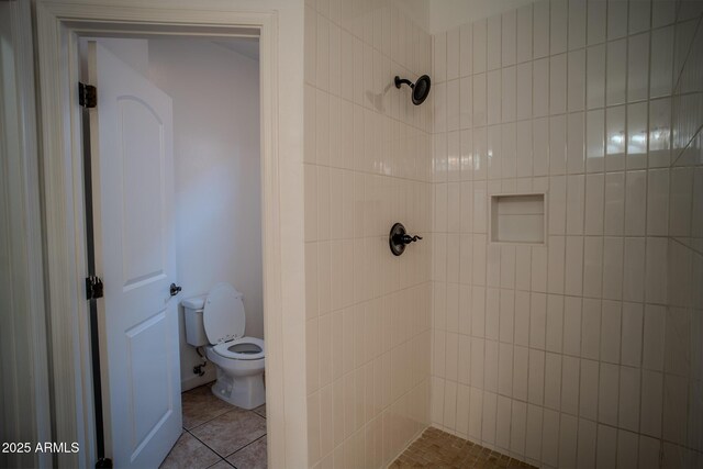 full bath with toilet, tiled shower, and tile patterned floors