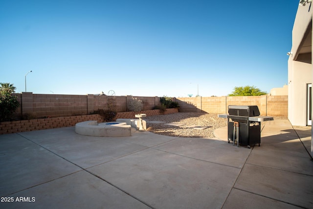 view of patio / terrace featuring area for grilling, a fenced backyard, and an outdoor fire pit