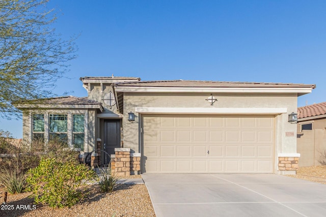 view of front facade with stucco siding, a garage, and driveway