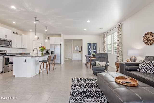 living room featuring recessed lighting, baseboards, and light tile patterned floors