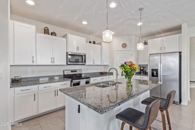 kitchen with a sink, white cabinetry, and stainless steel appliances