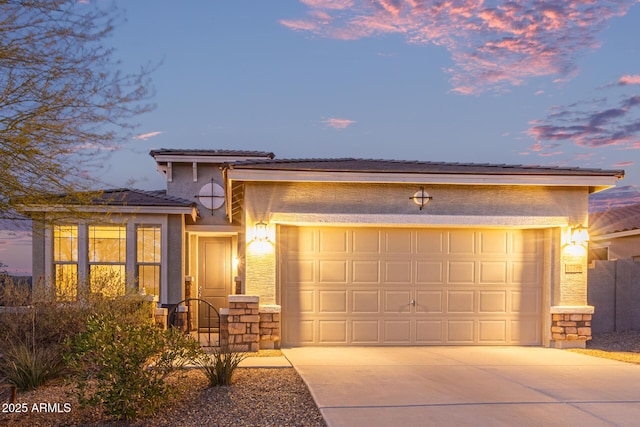 view of front of house with stone siding, stucco siding, driveway, and a garage