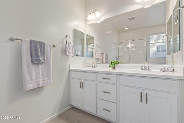 full bath with double vanity, visible vents, a stall shower, and a sink