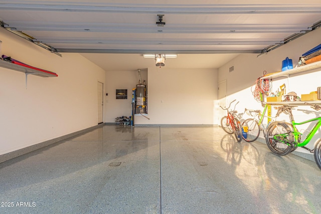 garage featuring visible vents, a garage door opener, baseboards, and water heater