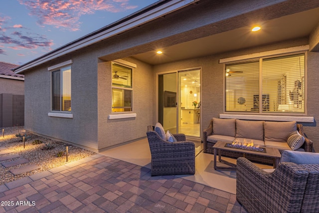 view of patio with an outdoor living space with a fire pit