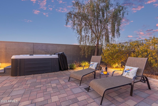 view of patio / terrace with a fenced backyard, central AC, and a hot tub