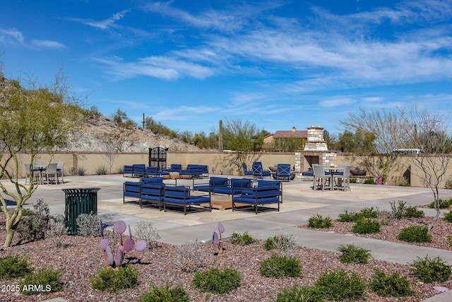 view of patio / terrace with exterior fireplace and fence