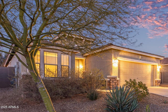 view of front of house featuring concrete driveway, an attached garage, and stucco siding