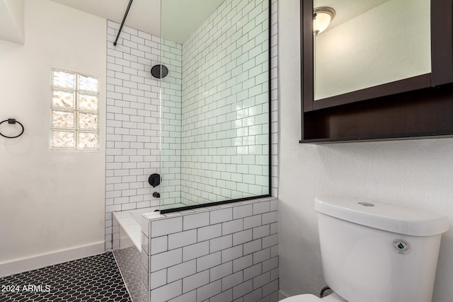 bathroom featuring tiled shower, toilet, and tile patterned flooring