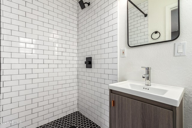 bathroom featuring vanity and tiled shower