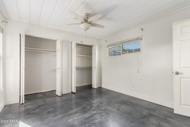 unfurnished bedroom with two closets and ceiling fan