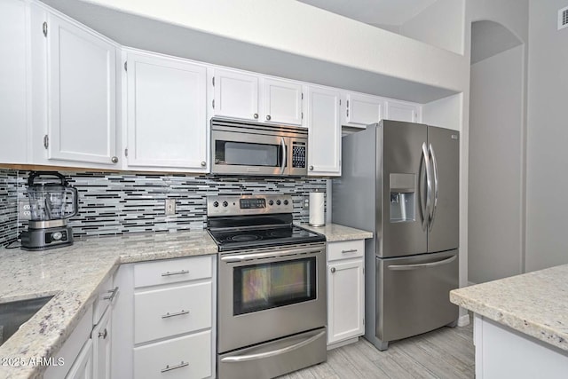 7949 W Wescott Dr, Glendale, AZ 85308 - kitchen featuring stainless steel appliances, white cabinetry, tasteful backsplash, and light wood-type flooring