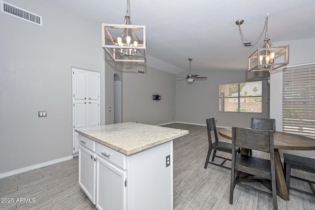 7949 W Wescott Dr, Glendale, AZ 85308 - kitchen featuring a chandelier, a ceiling fan, light wood-style floors, hanging light fixtures, and lofted ceiling