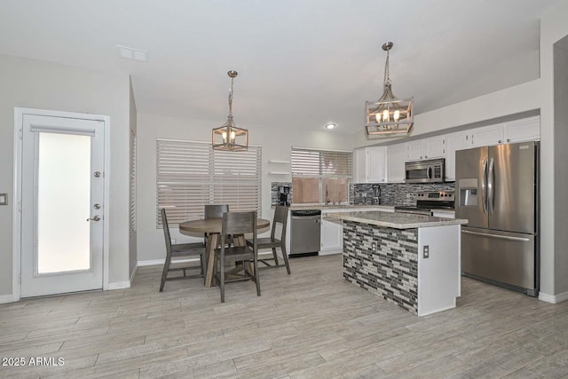 7949 W Wescott Dr, Glendale, AZ 85308 - kitchen featuring appliances with stainless steel finishes, a chandelier, white cabinets, light countertops, and decorative backsplash