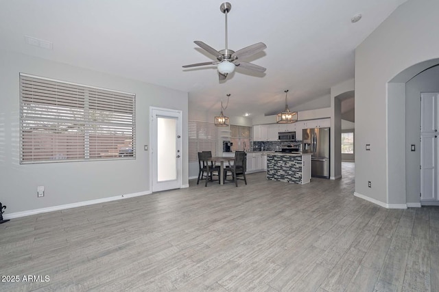 7949 W Wescott Dr, Glendale, AZ 85308 - living room with ceiling fan, arched walkways, light wood-type flooring, baseboards, and vaulted ceiling