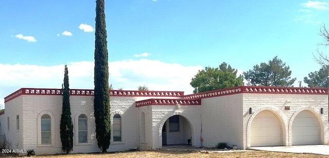 904 E Christmas Tree Ln, Pearce, AZ 85625 - mediterranean / spanish-style home with an attached garage, driveway, and brick siding