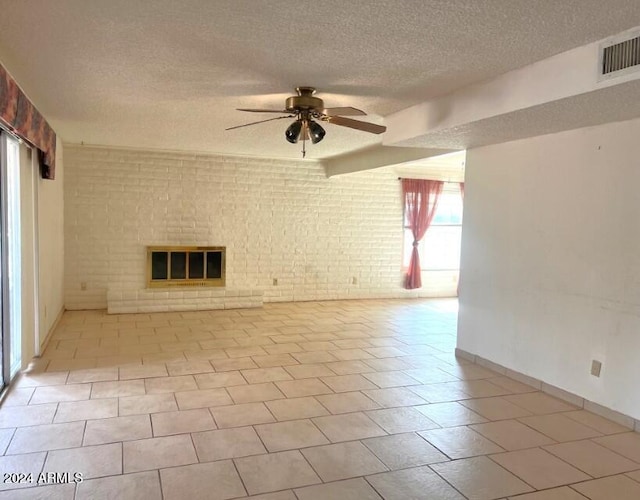 904 E Christmas Tree Ln, Pearce, AZ 85625 - unfurnished living room with a textured ceiling, ceiling fan, brick wall, a brick fireplace, and baseboards