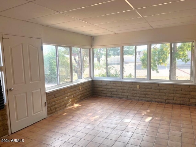 904 E Christmas Tree Ln, Pearce, AZ 85625 - unfurnished sunroom with a drop ceiling, brick wall, and tile patterned flooring