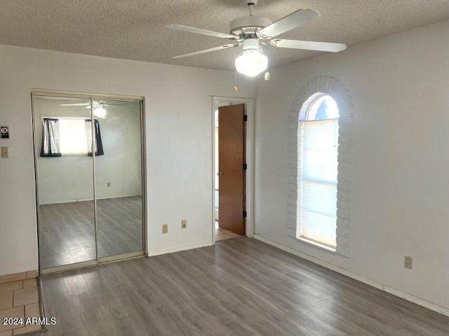 904 E Christmas Tree Ln, Pearce, AZ 85625 - unfurnished bedroom with a textured ceiling, wood finished floors, a closet, ceiling fan, and baseboards