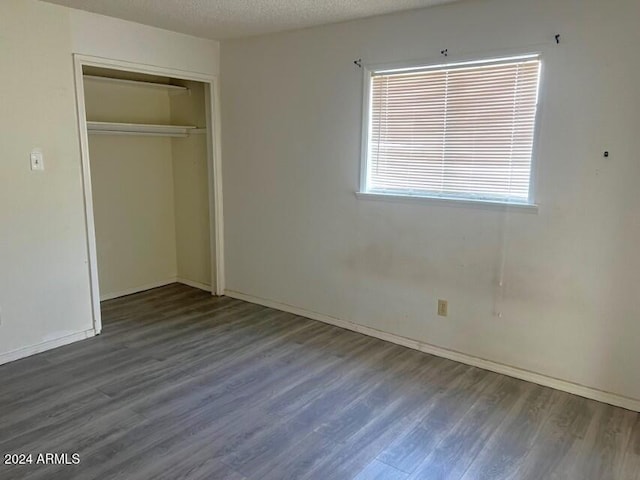 904 E Christmas Tree Ln, Pearce, AZ 85625 - unfurnished bedroom featuring wood finished floors, a closet, a textured ceiling, and baseboards