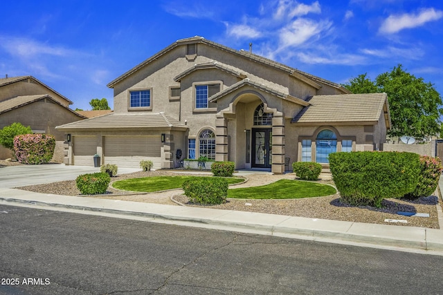 view of front facade featuring stucco siding, french doors, a tile roof, and concrete driveway