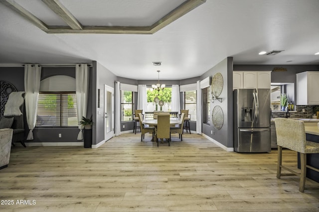 dining room with baseboards, visible vents, and light wood-style flooring