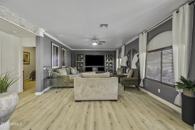 living area with light wood-style floors, baseboards, a ceiling fan, and visible vents