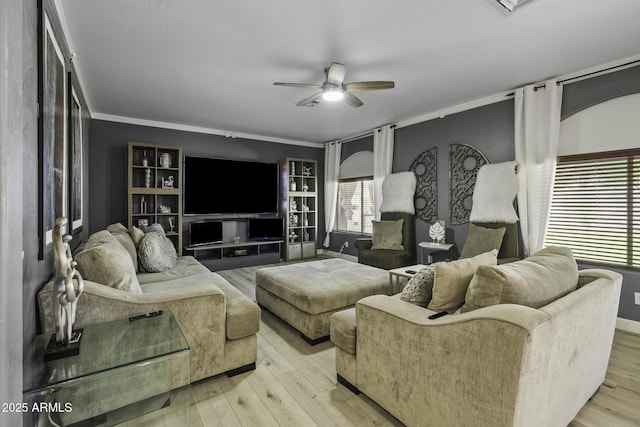 living room featuring baseboards, plenty of natural light, a ceiling fan, and light wood finished floors