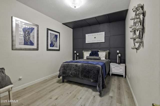 bedroom featuring baseboards and light wood-type flooring