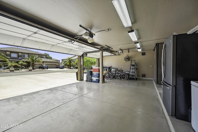 garage with freestanding refrigerator and a garage door opener